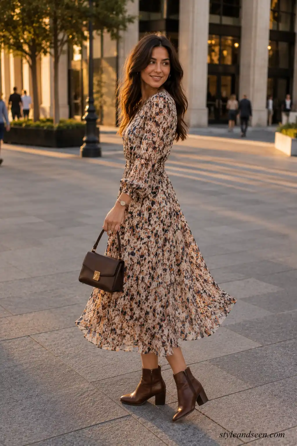 Young woman wearing a stylish printed midi dress with ankle boots and a structured handbag for a modern going-out look.