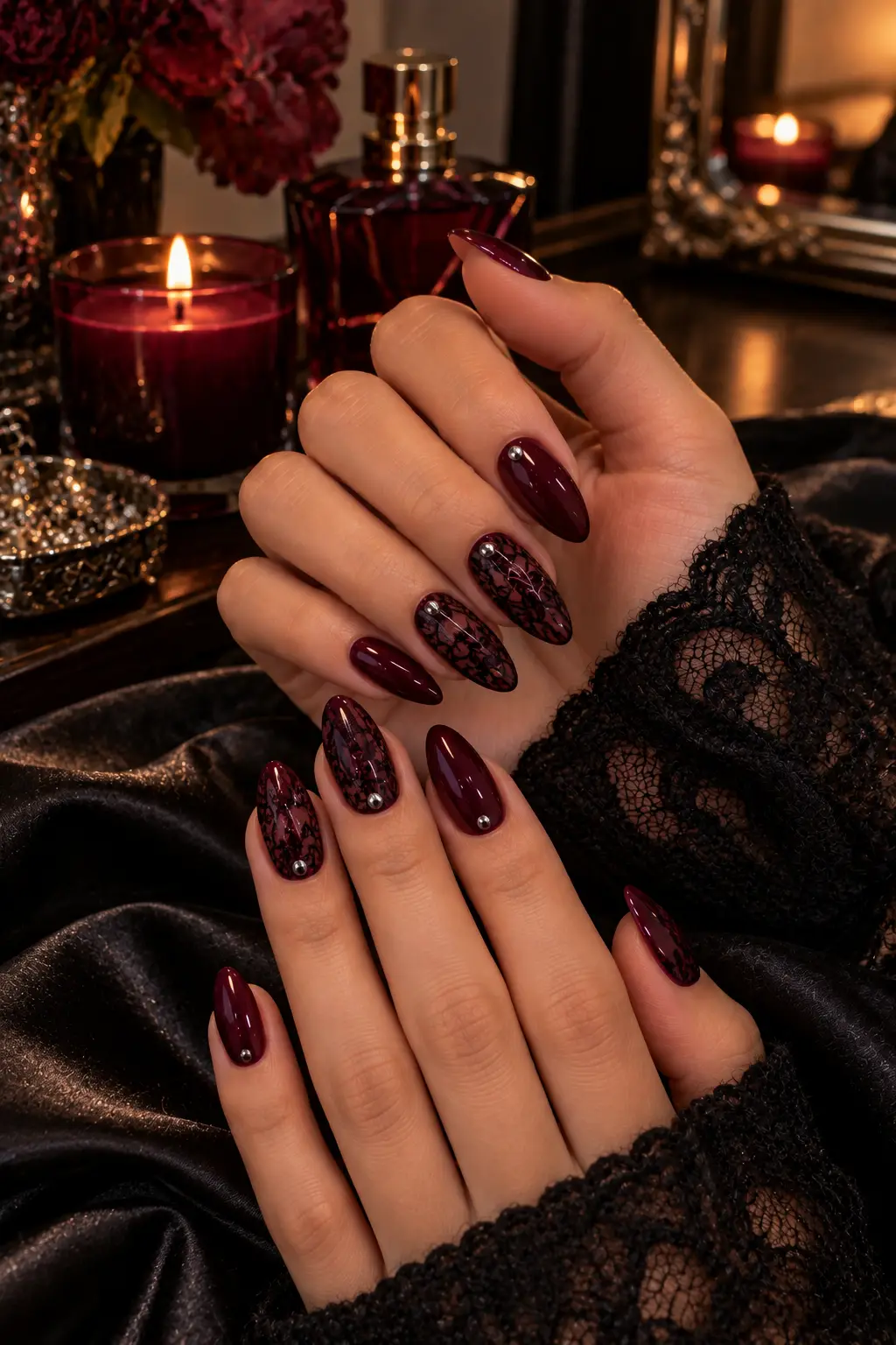 Deep burgundy nails with black lace pattern accent nails and a tiny silver stud on the ring finger