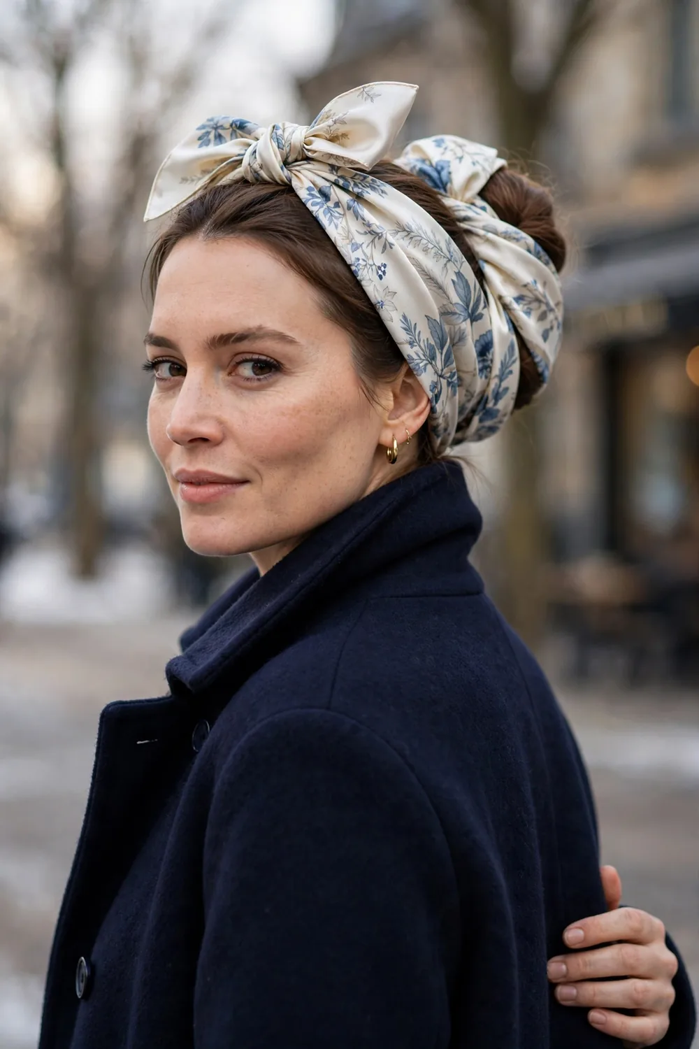 Satin scarf wrapped around a low bun with elegant printed fabric on a woman in a wool coat